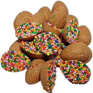 A pile of Mini Half Easter Eggs in Caramel Chocolate half-covered with colourful sprinkles.