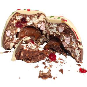 Bliss Dome cut open to reveal its filling, with a white chocolate topping and red and green decorations.