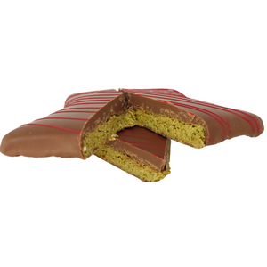 Side view of a cut Dubai Pistachio Star showing its green filling, with a piece placed in front.