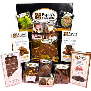 A Poppy's Chocolate gift hamper featuring an assortment of packaged chocolates, truffles, and chocolate bars arranged in front of a black gift box on a white background.