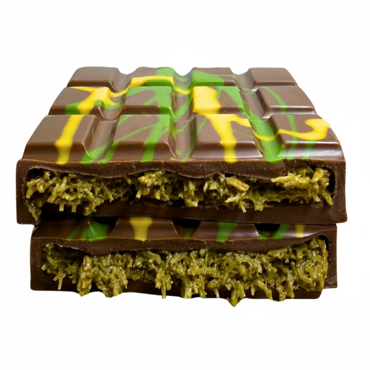 A pistachio and kataifi Bliss Block broken in half and stacked with a green textured filling and yellow drizzle, photographed on a plain white background.