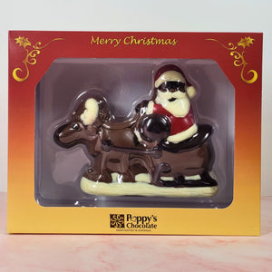 Front view of the Christmas gift box showing the chocolate Santa, reindeer and sleigh through the clear window.