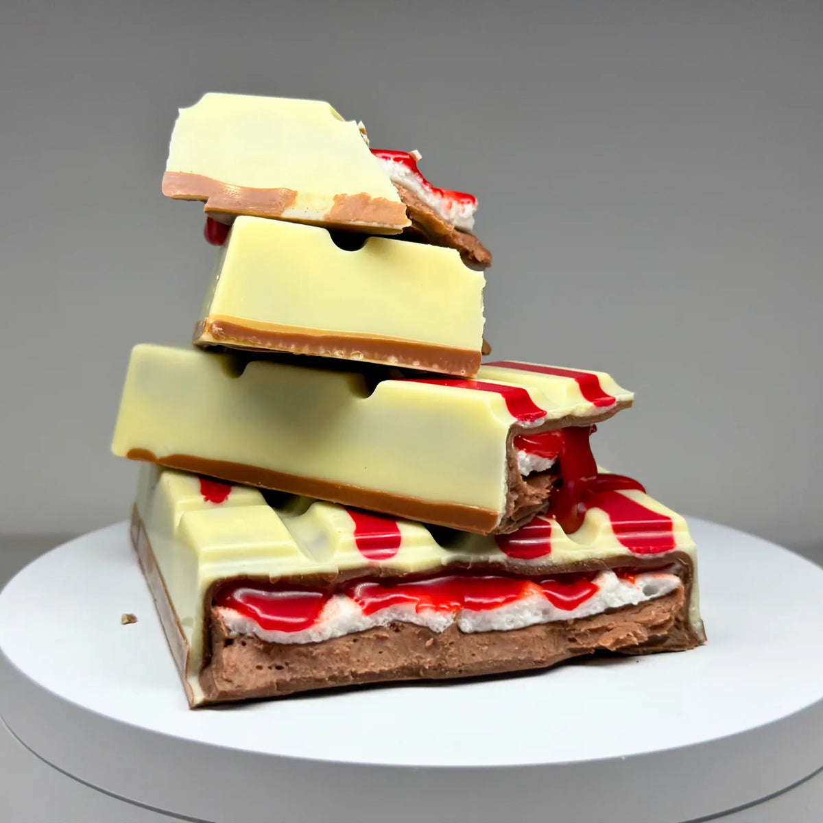 Blood Moon Bliss Block featuring a milk and white chocolate shell with red detailing, revealing layers of red salted caramel, fluffy marshmallow and raspberry milk chocolate ganache.