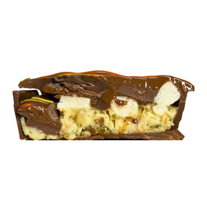 Citrus Pie cut in half showing lemon curd, lime, mini marshmallows and milk chocolate filling with a shortbread biscuit.