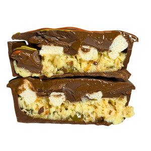 Citrus Pie cut in half showing lemon curd, lime, mini marshmallows and milk chocolate filling with a shortbread biscuit.