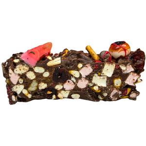 Graveyard Rocky Road made with milk and dark chocolate, crunchy pretzels, glacé cherries and freeze-dried raspberries, topped with spooky Halloween decorations.
