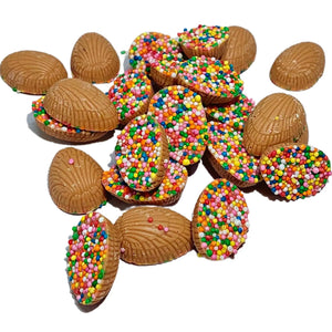 A pile of Mini Half Easter Eggs in Caramel Chocolate half-covered with colourful sprinkles. 