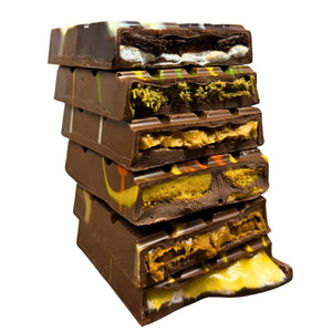 Stack of layered dessert bars with different textures on a pink background