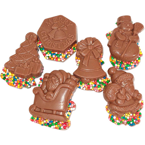 Assorted Christmas milk chocolate shapes with colourful sprinkles visible around the edges.