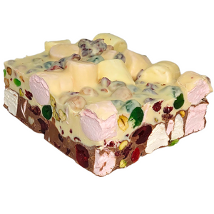 A block of rocky road with layers of green and red glace cherries, pistachios, honey roasted macadamias, cranberries and marshmallows, all in creamy milk and white chocolate.
