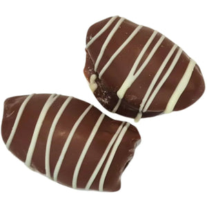 Chocolate-coated peanut crunch dates with white chocolate drizzle, shown whole and cut open.