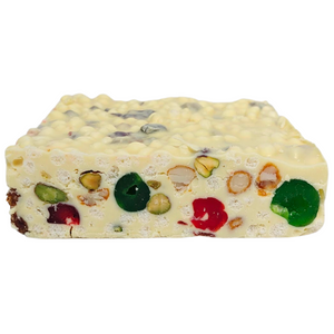 Front view of Poppy’s White Christmas 500g block showing fruit, nuts and rice puffs in white chocolate.