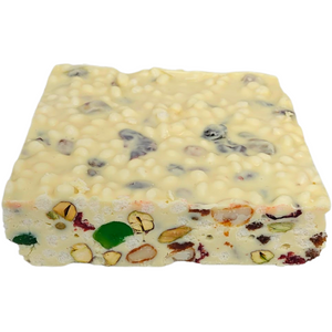 Poppy’s White Christmas 500g block showing the textured top and cut face with cherries, nuts and rice puffs.