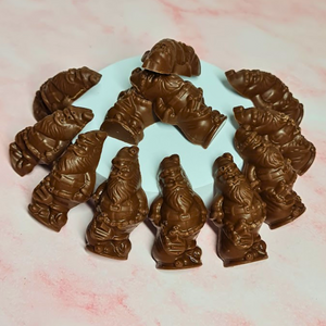 Milk chocolate Santas with salted caramel filling arranged around a pale blue circular stand.