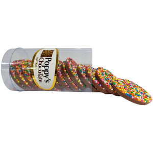 Chocolate bark cookies with colorful sprinkles, shown with a clear cylindrical container labeled 'Poppy's Chocolate' on a white background.