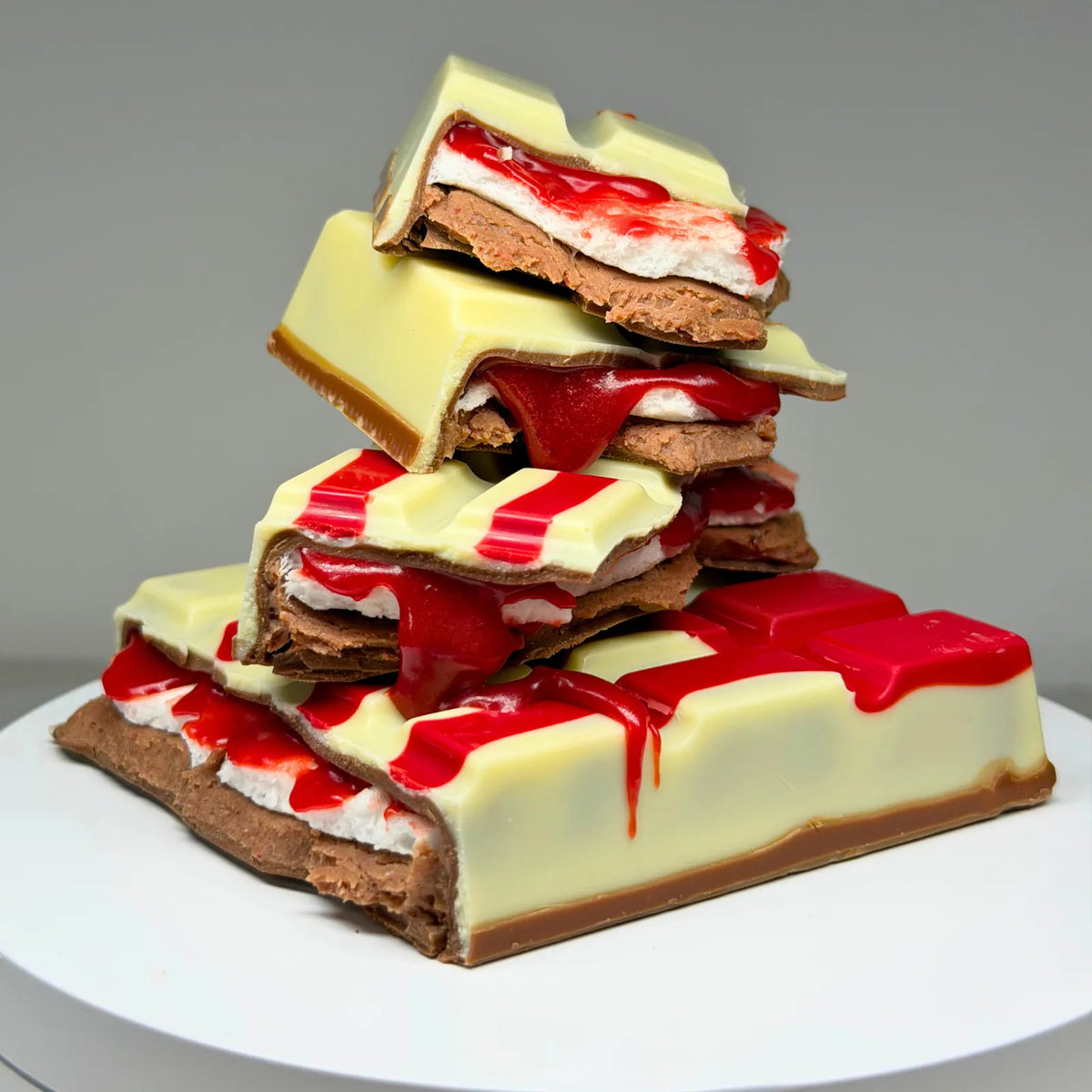 Blood Moon Bliss Block featuring a milk and white chocolate shell with red detailing, revealing layers of red salted caramel, fluffy marshmallow and raspberry milk chocolate ganache.