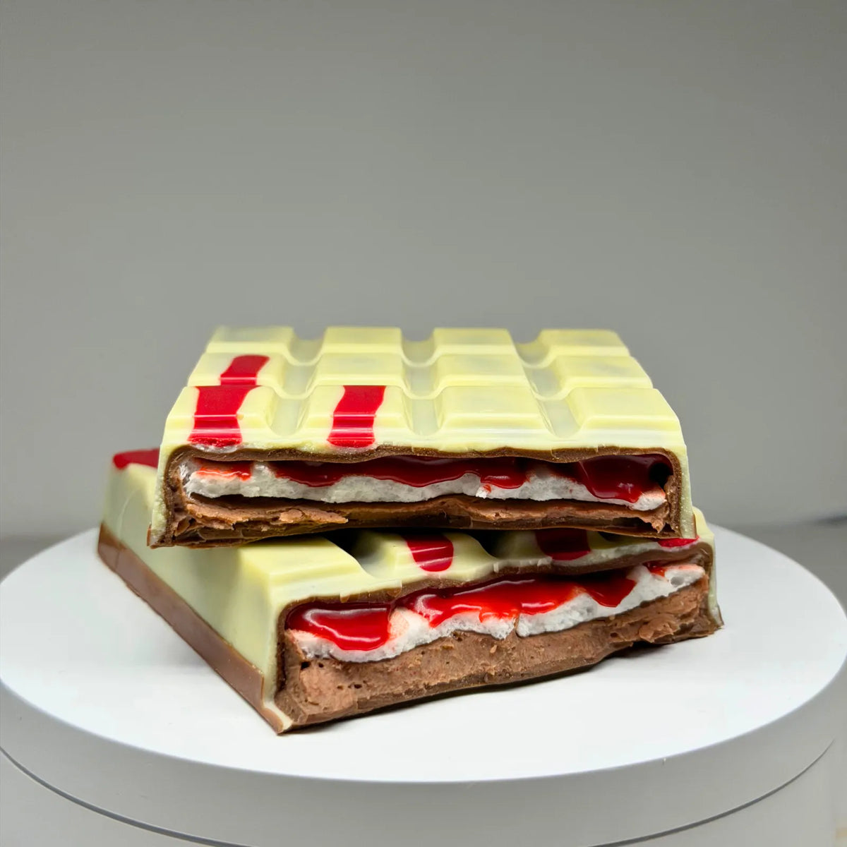 Blood Moon Bliss Block featuring a milk and white chocolate shell with red detailing, revealing layers of red salted caramel, fluffy marshmallow and raspberry milk chocolate ganache.
