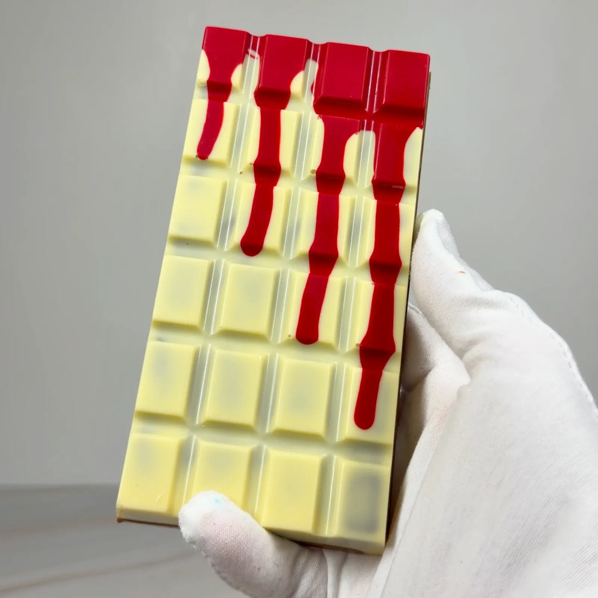 Blood Moon Bliss Block featuring a milk and white chocolate shell with red detailing, revealing layers of red salted caramel, fluffy marshmallow and raspberry milk chocolate ganache.