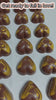 Hand making caramel filled chocolate hearts decorated with yellow chocolate
