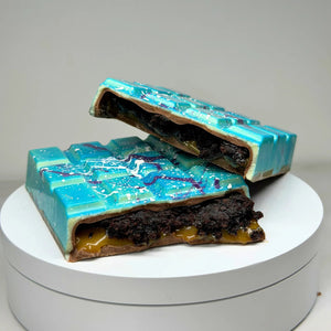 Handmade milk chocolate Salted Caramel Chocolate Brownie Bliss Block with a blue and violet chocolate finish, gluten-free mud cake and gooey salted caramel filling.