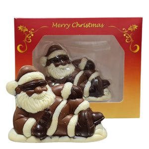 Santa Cool & Easy milk chocolate figure wearing sunglasses and reclining in front of its red and gold Christmas gift box.