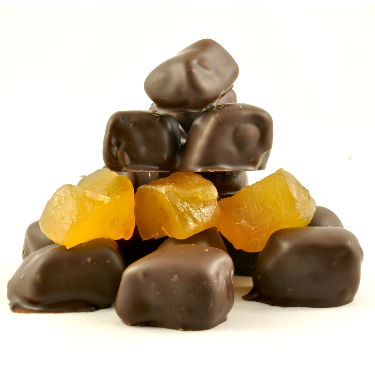 A pyramid of Poppy’s Chocolate Dark Chocolate Coated Ginger candies is arranged with vibrant, translucent yellow pieces interspersed throughout, set against a plain white background, making it an ideal gift.